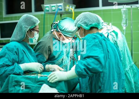 Gruppe von Chirurgen bei der Arbeit im Op. Reanimation Medizin team das Tragen von Schutzmasken holding Stahl medizinische Werkzeuge speichern patie Stockfoto