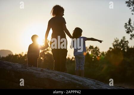 Mutter und Kinder erkunden die Natur bei Sonnenuntergang Stockfoto