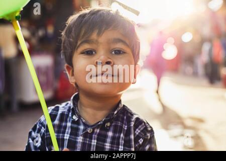 Kleiner Junge mit Ballon, der auf dem Basar spazieren geht Stockfoto
