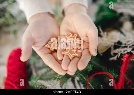 Hand mit Weihnachtsschmuck, Lebkuchenmann, Stern und Baum Stockfoto