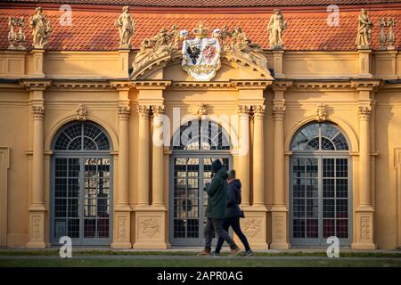 Erlangen, Deutschland. Januar 2020. Spaziergänger gehen im Palastgarten entlang der Orangerie, die von der Nachmittagsonne beleuchtet wird. Credit: Daniel Karmann / dpa / Alamy Live News Stockfoto