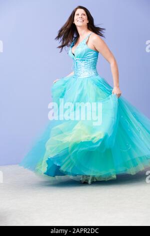 Blick auf eine junge Frau, die im Abendkleid tanzt. Stockfoto