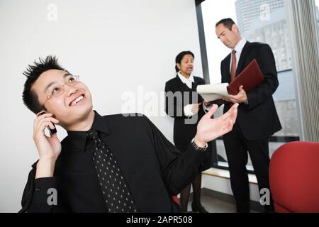 Ansicht des Architekten Moblie telefonieren mit Geschäftsfrau und Mann diskutieren. Stockfoto