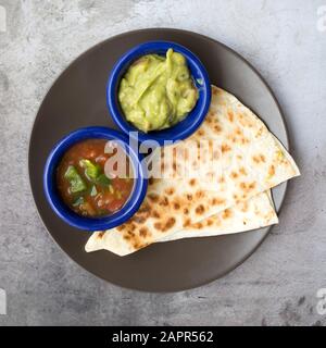 Käse Quesadilla mit Guacamole und Salsa Stockfoto