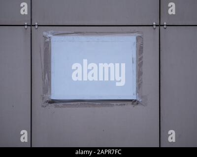 Eine Papiernachricht, die mit Klebeband an die Wand geklebt wurde und für Ihren Text oder Ihr Bild angebracht ist. Leere Mockup-Vorlage mit Copyspace. Grunge Wand Stockfoto