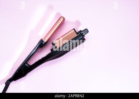 Multi-Styler für Haare. Eisenstirn. Auf pinkfarbenem Hintergrund. Platz für Text, freier Platz für Platz zum Kopieren Stockfoto