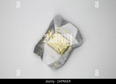 Draufsicht Nahaufnahme des isolierten Stücks Kraut Weichkäse auf Aluminiumfolie, weißer leerer Hintergrund Stockfoto
