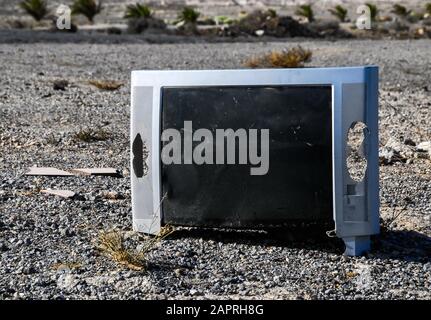 Selektive Fokusaufnahme eines defekten Bildschirms eines Fernsehers Platziert auf einer felsigen Oberfläche Stockfoto