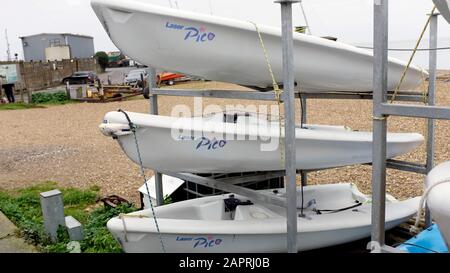 Drei kleine Segelboote von Laser Pico, die sich in der Nähe der Küste befinden. Stockfoto