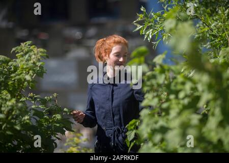 Junge Frau in einem städtischen Garten in einer Stadt Stockfoto