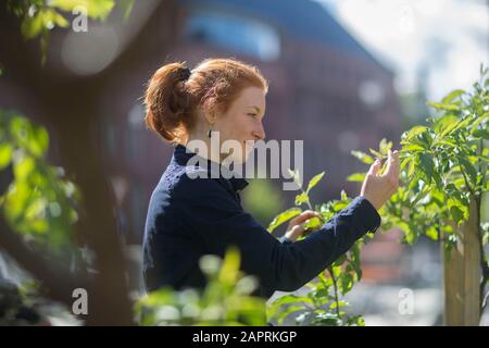 Junge Frau in einem städtischen Garten in einer Stadt Stockfoto