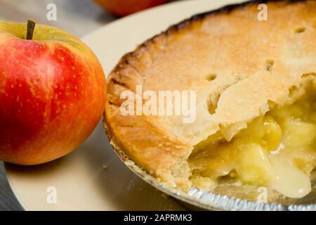 Nahaufnahme eines roten Apfels neben dem geschnittenen Cremige Torte Stockfoto
