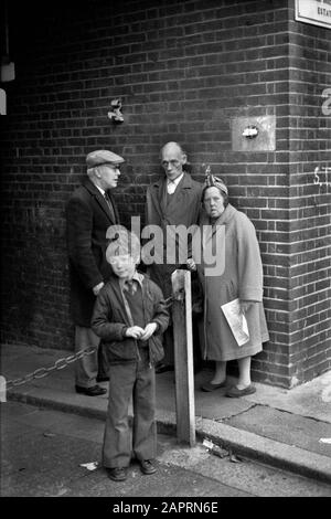 Arbeiterfamiliengruppe Armut London 1970er Jahre Mutter Vater Kinder und älterer Freund tragen eine flache Mütze. 1976. UK HOMER SYKES Stockfoto