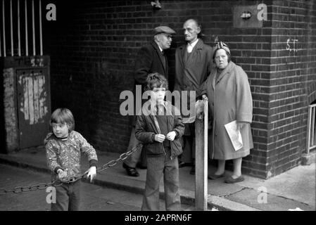 Arbeiterklasse Familie Gruppe Armut 1970s UK Mutter Vater Kinder und ein Freund mit flacher Mütze, South London England 1976 HOMER SYKES Stockfoto