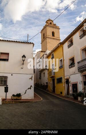 Schöner Blick auf eine Gasse in Polop, Spanien unter blauem Himmel Stockfoto