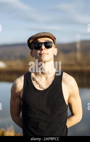 Nahaufnahme Porträt des jungen Mannes trägt Sonnenbrille und Hut an sonnigen Tag Stockfoto