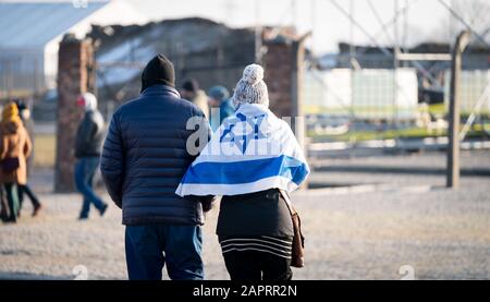 Oswiecim, Polen. Januar 2020. Ein Besucher trägt eine israelische Flagge im ehemaligen Vernichtungslager Auschwitz-Birkenau. 27.01.2020 ist der 75. Jahrestag der Befreiung des Konzentrationslagers durch die Rote Armee. Von 1940 bis 1945 Betrieb die SS den Komplex mit zahlreichen Satellitenlagern als Konzentrations- und Vernichtungslager. Die Zahl der Ermordeten beläuft sich auf 1,1 bis 1,5 Millionen, die meisten von ihnen Juden. Auschwitz steht als Symbol des industriellen Massenmordes und der Judenvernichtung. Credit: Kay Nietfeld / dpa / Alamy Live News Stockfoto