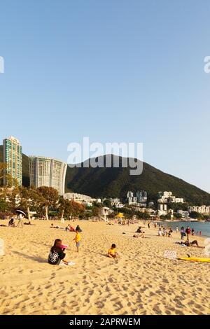 Hong Kong Beach - Menschen, die am Strand in der Repulse Bay auf der südlichen Seite von Hong Kong Island, Hong Kong Asia, sonnen Stockfoto