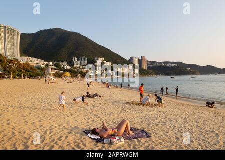 Hong Kong Beach - Menschen, die am Strand in der Repulse Bay auf der südlichen Seite von Hong Kong Island, Hong Kong Asia, sonnen Stockfoto