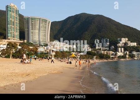 Hong Kong Beach - Menschen, die am Strand in der Repulse Bay auf der südlichen Seite von Hong Kong Island, Hong Kong Asia, sonnen Stockfoto