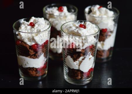 Süßes Dessert mit Rotkräuseln, Schlagsahne und Brownies Stockfoto