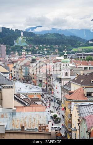 Innsbruck, Österreich - 29. Juli 2019: Blick auf eine Hauptstraße in der Altstadt von Innsbruck in der österreichischen Landeshauptstadt. Berge im Hintergrund. Stockfoto