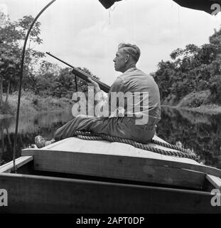 Reise nach Suriname und auf den niederländischen Antillen EIN Reisebegleiter des Fotografen Willem van de Poll, Mr. De Haas, mit einem Gewehr am Bug eines Korjals auf dem Coppenamerivier in Suriname Datum: 1947 Ort: Suriname Schlüsselwörter: Artillerie, Flüsse, Schiffe Personenname: Haas, [.] der Stockfoto