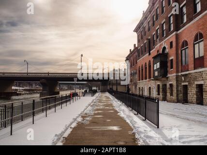 Oswego, New York, USA. Januar 2022. Laufsteg entlang des Oswego River im Stadtzentrum von Oswego, New York an einem Winternachmittag Stockfoto