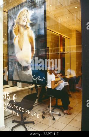 Frankreich. Paris. Franck Provost Coiffure. Blick durch das Schaufenster der Friseursalon, die jungen Männern die Haare schneidet. Stockfoto