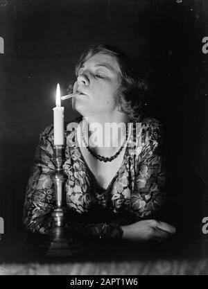 Werbefotografien EINE Frau zündet eine Zigarette an einer Kerze Datum: 1932 Schlüsselwörter: Rauchen, Zigaretten, Frauen Stockfoto