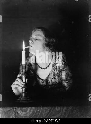 Werbefotografien EINE Frau zündet eine Zigarette an einer Kerze Datum: 1932 Schlüsselwörter: Rauchen, Zigaretten, Frauen Stockfoto