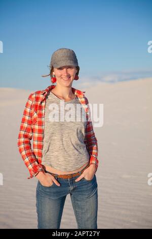 Porträt einer jungen Frau auf dem weißen Sand mit blauem Himmel, White Sands National Monument; Alamogordo, New Mexico, Vereinigte Staaten von Amerika Stockfoto