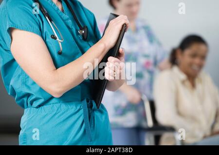 Mittelteil einer Krankenschwester mit Stethoskop und Feile. Stockfoto