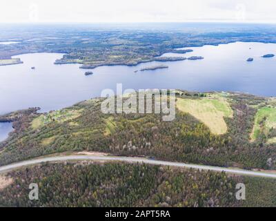 Schöner Blick von einer Straße durch den schönen See und Wald, auf beiden Seiten mit Wasser umgeben, oben von Drohne, luftige leuchtende Pic Stockfoto