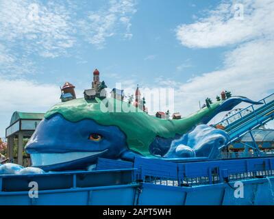 Große Blauwalattraktion mit Häusern und Bäumen darauf. Wasserattraktion. Russland Sotschi 06 22 2019 Stockfoto