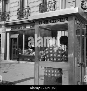 Pariser Bilder [Das Straßenleben von Paris] Verwendung einer Telefonzelle Datum: 1965 Standort: Frankreich, Paris Stichwörter: Straßenbilder, Telefonzellen