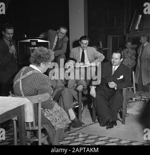 Filmregisseur Gerard Rutten im Filmstudio Gerard Rutten (mit alpino) am Set mit dem Filmproduzenten Joop Geesink (rechts) Anmerkung: Joop Geesink ist der Schöpfer von Loeki de Leeuw Datum: 10. Dezember 1953 Ort: Amsterdam Schlagwörter: Schauspieler, Kameraleute, Filmstudios, Regisseure, Arbeitsaufnahmen persönlicher Name: Geesink, Joop, Rutten, Gerard Stockfoto