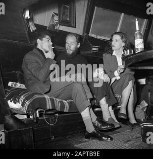 Das Segel-Hausboot Siegfried & Erik am Ufer der seine Company an Bord des Schiffes Siegfried & Erik, in Paris Datum: 1950 Standort: Frankreich, Paris Schlüsselwörter: Besucher, Innenräume, Kerzen, Rauchen, Wein Stockfoto