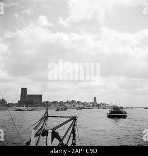 Rijnvaart, Bericht von Schlepper Damco 9: Westdeutschland Blick auf Emmerich mit am Kai angedockten Lastkähnen Anmerkung: Im Hintergrund der St. Martini-Münsterkirche und der Aldegundiskirche Datum: 1. April 1955 Standort: Deutschland, Emmerich, Westdeutschland Schlagwörter: Lastkähne, Kirchenbauten, Flüsse, Stadtbilder, Dampfschiffe Stockfoto