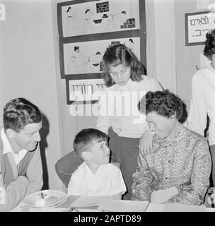 Israel 1964-1965: Gal'ed, seit Abend Familie im Kibbutz Gal'ed während der Seidermeal Anmerkung: Gal'ed (auch Yitzhak genannt) ist ein Kibbutz im Norden Israels, der sich in der Ebene von Manasse befindet. Im Jahr 2006 hatte sie 405 Einwohner. Seder Evening (auch Seideravond genannt) ist ein Abend zu Beginn des Passahfestes, an dem Juden aus der Haggada lesen (Broschüre über die Geschichte der jüdischen Sklaverei in Ägypten und den Auszug aus Ägypten), 4 Gläser Wein (oder Traubensaft) und ein festliches Sedermahl trinken. Seder bedeutet wörtlich Ordnung oder Ordnung, denn die Sitten werden entsprechend ausgeführt Stockfoto