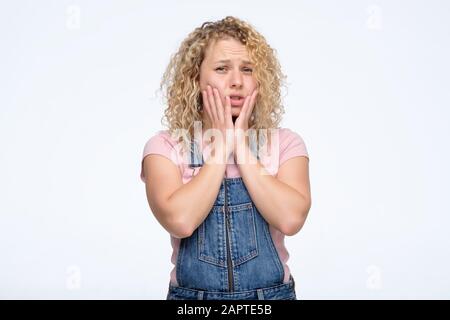 Schockiert verblüffte Mädchen bedecken den Mund mit den Händen Blick auf die Kamera fühlt Angst Pose. Unangenehme Nachrichten entsetzten das Konzept der gestressten Situationen Stockfoto