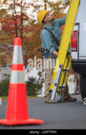 Handwerker mit Leiter und Arbeitswagen Stockfoto