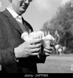 Spaarnestad Photo/Cevirum, SFA006007889 Mann mit den Händen voller Eiscreme. Mann, der zu viele Eiscremes hält. Ort und Datum unbekannt. Stockfoto