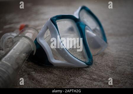 Maske und Schnorchel in der Brandung am Strand; selektiver Fokus, Maske und Schnorchelschlauch am Sand Stockfoto