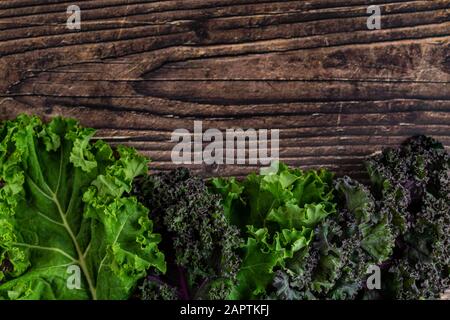 Grünes, belaubtes kaltes Gemüse isoliert auf Holztischhintergrund Stockfoto