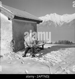 Winter Hilde Eschen auf einer Bank an der Lemmenhof-Kapelle im Schnee mit Hintergrund die Karwendelberge Datum: Januar 1960 Standort: Österreich, Sistrans, Tyrol Schlüsselwörter: Berge, Kapellen, Landschaften, Schnee, Urlaub, Winter persönlicher Name: Echen, Hilde Stockfoto