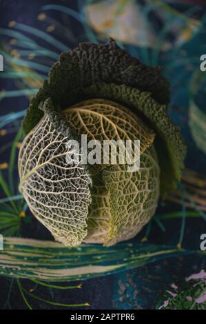 Krinkliger savoyenkohl saß auf einer gemusterten Fabika. Stockfoto