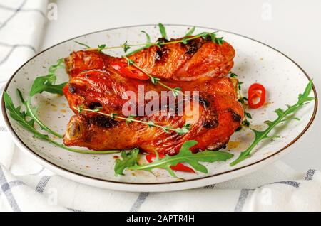 Gebraten würzige Hähnchenkeulen oder Drumsticks auf einem weißen Teller. Köstliche Mittag- oder Abendessen. Stockfoto