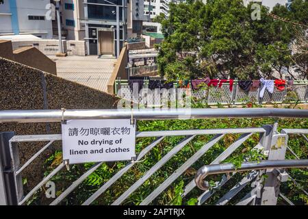 Zweisprachiges Beschrankungszeichen In Englisch Und Chinesisch Uber Das Verbot Des Trocknens Von Kleidung Und Nasser Kleidung Die Auf Dem Gelander Am Hintergrund In Hongkong Trocknet Stockfotografie Alamy