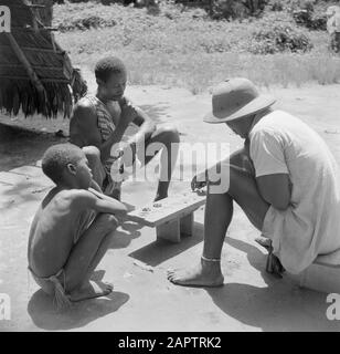 Reise nach Suriname und die niederländischen Antillen Jemand van der Polls Reisebegleiter spielt ein Brettspiel (Awari Bangi) mit den Waldkreolen Adauwna und Asadiri in Langetabbetje Datum: 1947 Ort: Langatabbetje, Marowijne, Suriname Schlüsselwörter: Waldkreolen, Gesellschaftsspiele Stockfoto